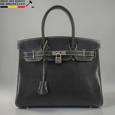 un gros plan sur un sac en cuir noir muni d'un cadenas