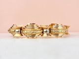 a close up of a gold bracelet on a white surface