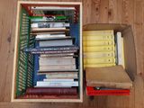une boîte remplie de livres posée sur un plancher en bois