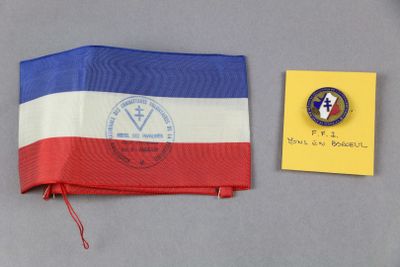 un drapeau rouge, blanc et bleu et un insigne à côté d'une feuille de papier jaune