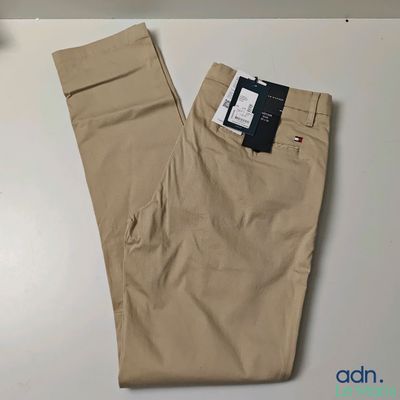 un pantalon kaki pour homme posé sur une table, avec une étiquette attachée