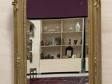 un miroir doré accroché au mur dans une salle de bains