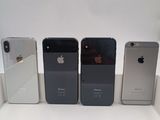 Quatre iPhones sont alignés les uns à côté des autres sur une surface blanche