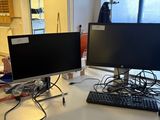 a desk with two computer monitors and a keyboard on it