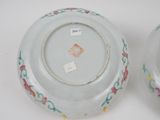pair of porcelain plates with floral designs on them on a white surface