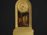 une image représentant une horloge en or ornée d'une peinture