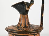 a black and orange vase with a handle on it