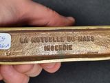 a hand holding a piece of metal that has writing on it