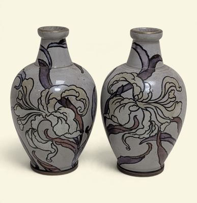 two vases that are sitting side by side on a white surface