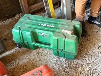 une boîte à outils verte posée par terre à côté d'une boîte à outils rouge