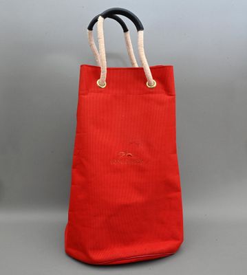 un sac fourre-tout rouge avec des anses en corde et une poignée noire