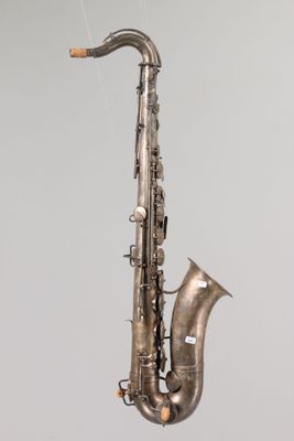a silver saxophone hanging from a string on the wall
