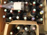 plusieurs bouteilles de vin dans un carton posé sur le sol
