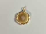 a close up of a gold locke with a diamond in the center