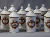 several white and brown canisters are lined up on a table