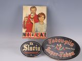 two advertising signs and a box of cigarettes on a table