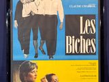 L'affiche du film « Les Bioches » est accrochée au mur.
