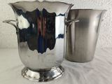 a silver vase and a silver cup on a table