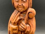 a wooden figurine of a monk holding a baby