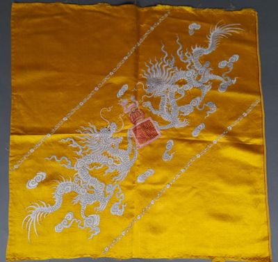 une nappe en soie jaune sur laquelle sont représentés un dragon et un autre dragon