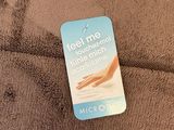 the label on the back of a brown towel that says feel me