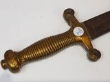 a gold colored sword on a white surface