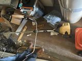 une photo d'un garage encombré avec des outils par terre
