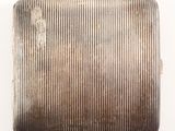 an antique silver cigarette case with a rusted surface on a white background