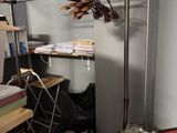 an image of a cluttered room with a desk and shelves