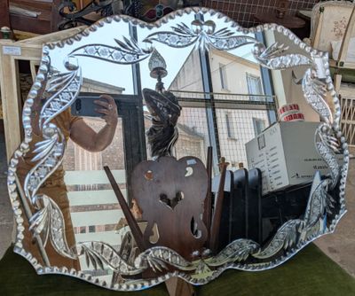 a mirror that is sitting on a chair in front of a window