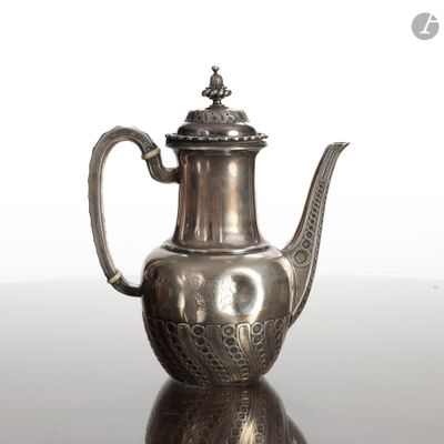 une théière en argent avec son couvercle, posée sur une table