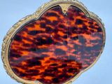 a tortoise shell shaped mirror on a stand