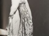 black and white photograph of a woman in a dress and fur coat