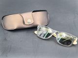 une paire de lunettes et son étui posés côte à côte sur une table