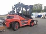 a red forklift truck parked in a parking lot