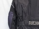 veste de moto noire avec des surpiqûres blanches et des fermetures éclair dans le dos