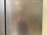 two stainless steel refrigerators sitting next to each other on a counter