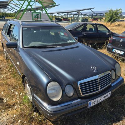 a car that is parked in the grass near other cars