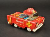 a toy fire truck with a fireman hat on top of it