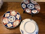 trois assiettes sur une table, avec un vase en arrière-plan