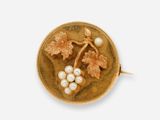 une image représentant une broche en or ornée de perles et de feuilles