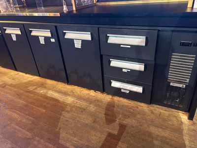 a black cabinet with four drawers and a computer on top of it