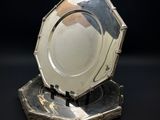 un plateau en argent posé sur un socle en argent