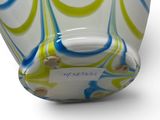 a glass vase that has a blue and yellow swirl design on it