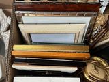 a cardboard box filled with assorted framed and unframed pictures