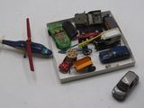 une petite boîte contenant des petites voitures et un hélicoptère miniature