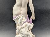an image of a figurine of a nude woman with a sheep