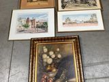 quatre photos encadrées posées par terre dans une pièce