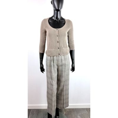 un mannequin vêtu d'un cardigan beige et d'un pantalon