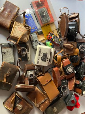 a pile of old cameras and other items on a table